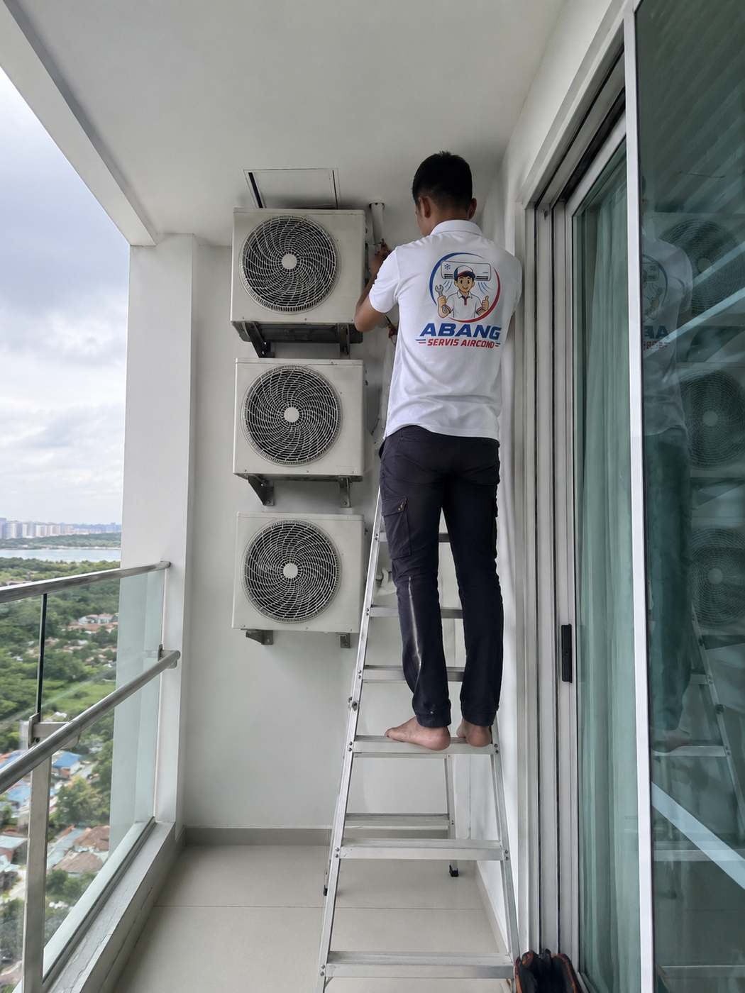 Servis unit kompresor aircond di balkoni kondominium